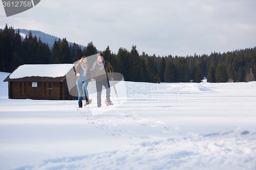 Image of couple having fun and walking in snow shoes