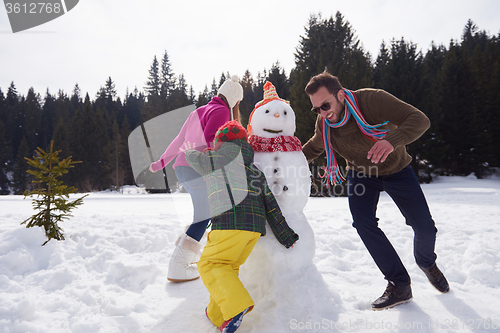 Image of happy family building snowman