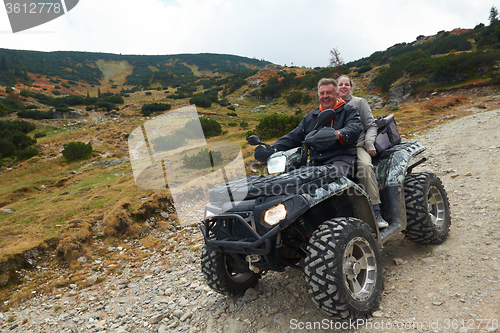 Image of couple drive atv quad bike