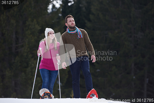 Image of couple having fun and walking in snow shoes