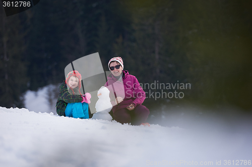 Image of happy family building snowman