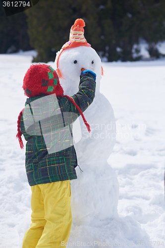 Image of boy making snowman