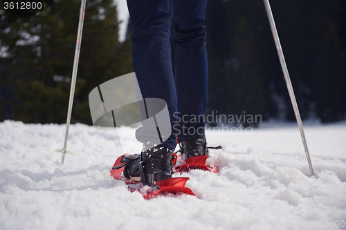 Image of couple having fun and walking in snow shoes