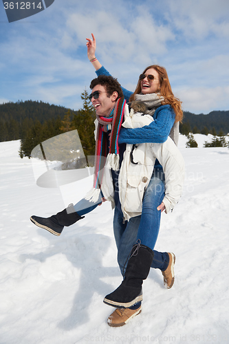 Image of happy young couple having fun on fresh show on winter vacation