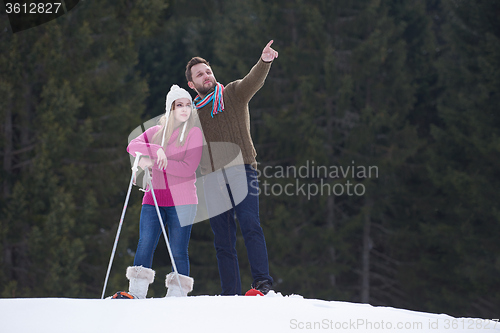 Image of couple having fun and walking in snow shoes