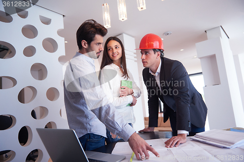 Image of couple buying new home with real estate agent