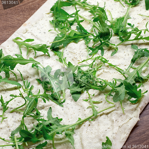 Image of Making lavash rolls with rucola and cheese