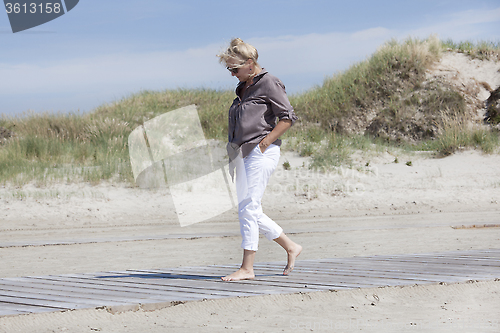 Image of Vacationer walking on beach path