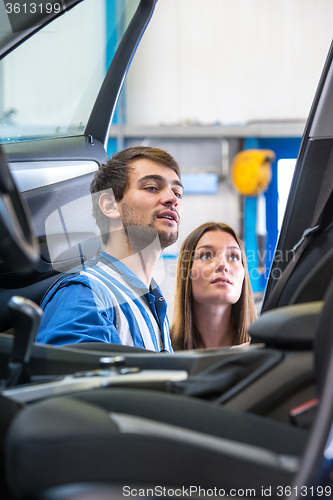 Image of Sales mechanic showing a woman the interior of a vehicle