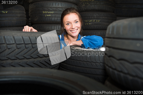 Image of Portrait of a female mechanic,surrounded by car tyres