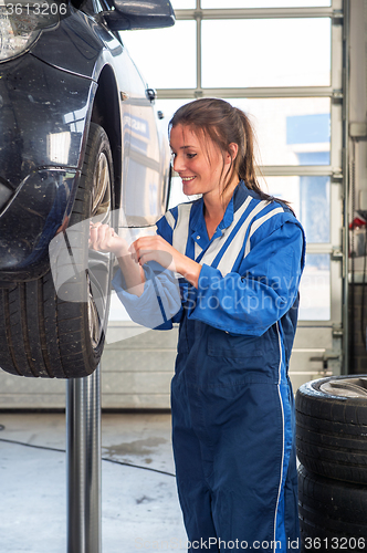 Image of Female mechanic replacing vehicle tyres