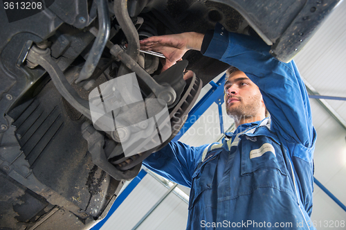 Image of Mechanic at work on the suspension system of a car