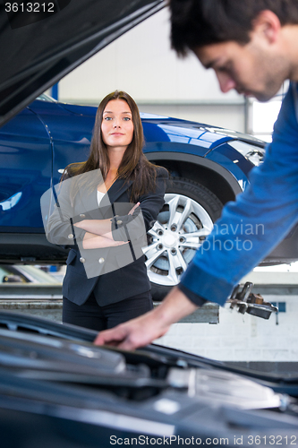 Image of Businesswoman waits for a mechanic to fix her car