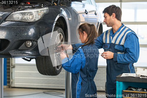 Image of Mechanic teaching an intern in a garage