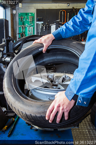 Image of Mechanic putting a tire on a light weight alloy rim