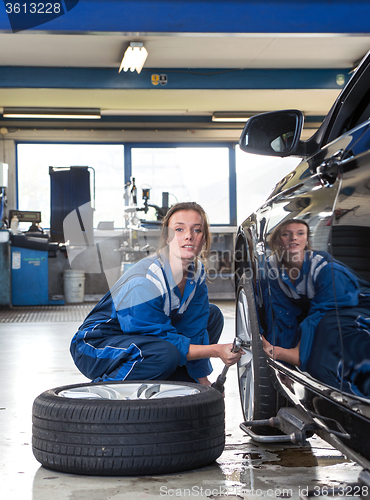 Image of Female mechanic changing a tyre