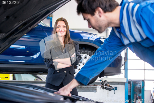 Image of Car owner happy with instant service by a professional mechanic