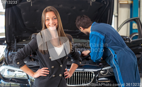 Image of Smiling woman in a car servicing garage