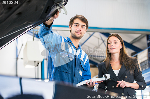 Image of Mechanic and customer looking under the hood of a car