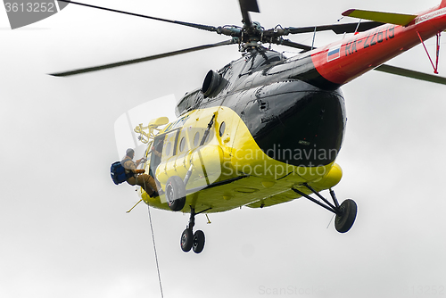 Image of Rescuer is landed from MI-8 helicopter by rope