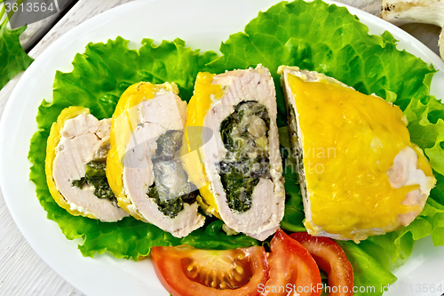Image of Roll chicken with spinach and lettuce on board
