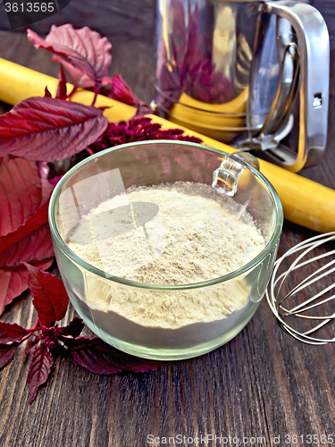 Image of Flour amaranth in glass cup on board with rolling pin