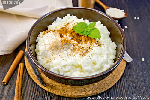 Image of Rice porridge with cinnamon in bowl on dark board