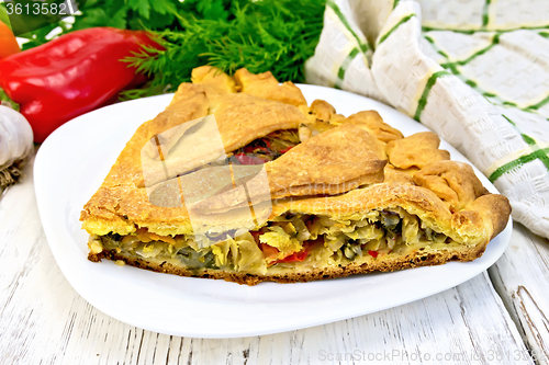 Image of Pie with cabbage and sorrel in plate on board