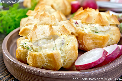 Image of Appetizer of radish and cheese in profiteroles on plate with dil