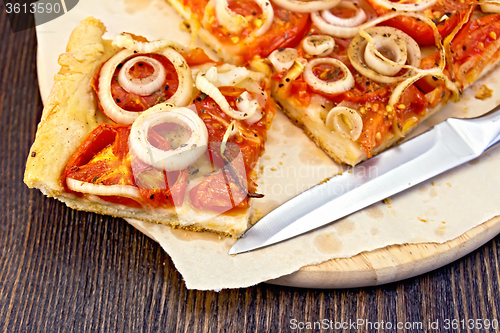 Image of Pie with onions and tomatoes on paper and board