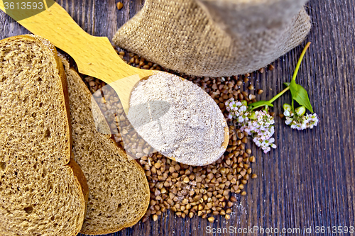 Image of Flour buckwheat in spoon with grains on board top