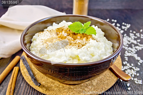 Image of Rice porridge with cinnamon in bowl on board