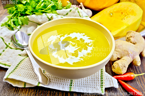 Image of Soup-puree pumpkin with cream in bowl on napkin and board