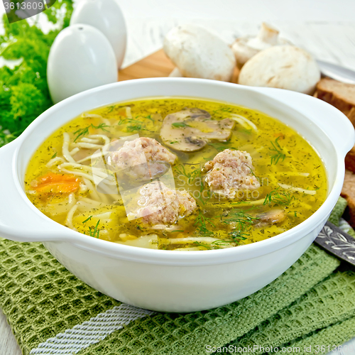 Image of Soup with meatballs and noodles in bowl on napkin