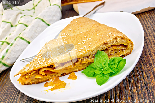 Image of Pie with cabbage and sesame in plate on board