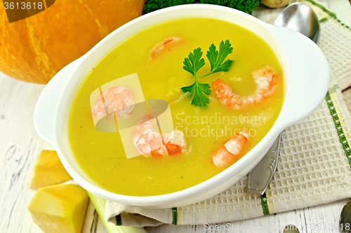 Image of Soup-puree pumpkin with shrimp in white bowl on board