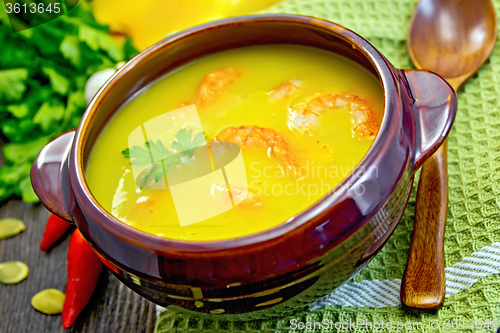 Image of Soup-puree pumpkin with shrimps in clay bowl on board