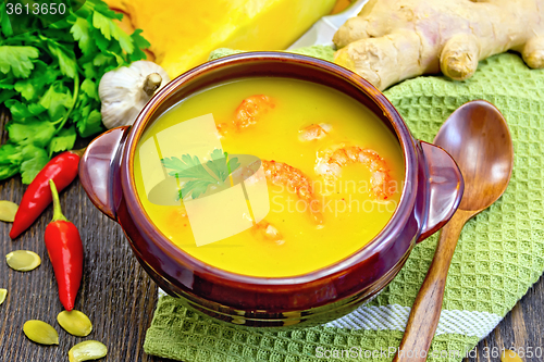 Image of Soup-puree pumpkin with shrimps in clay bowl on napkin