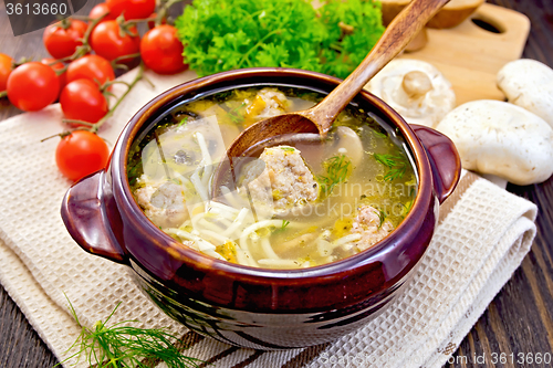 Image of Soup with meatballs and mushrooms in pottery on board