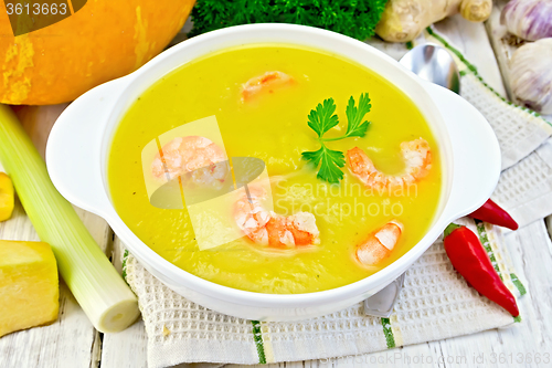 Image of Soup-puree pumpkin with shrimp in white bowl on napkin