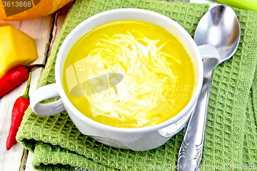 Image of Soup-puree pumpkin with cream in white bowl on napkin