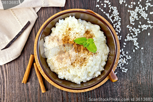 Image of Rice porridge with cinnamon in bowl on board top