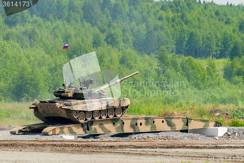 Image of T-80 tank drives on bridge induced through obstacle