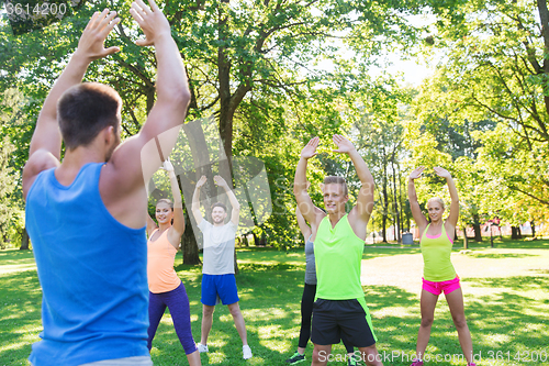 Image of group of friends or sportsmen exercising outdoors
