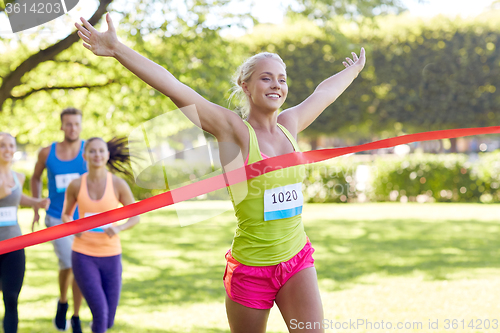 Image of happy young female runner winning on race finish