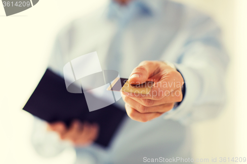 Image of close up of man holding wallet and credit card