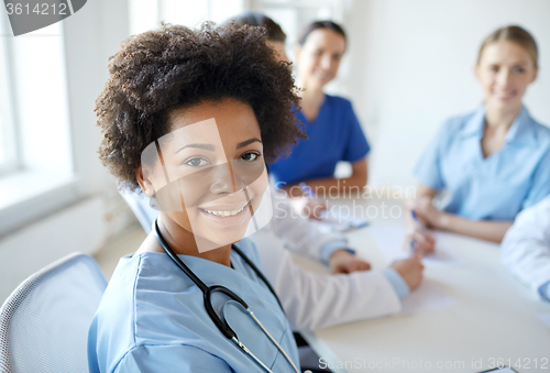 Image of happy doctor over group of medics at hospital