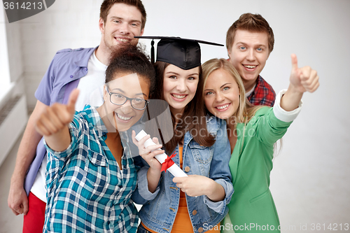 Image of smiling students with diploma showing thumbs up