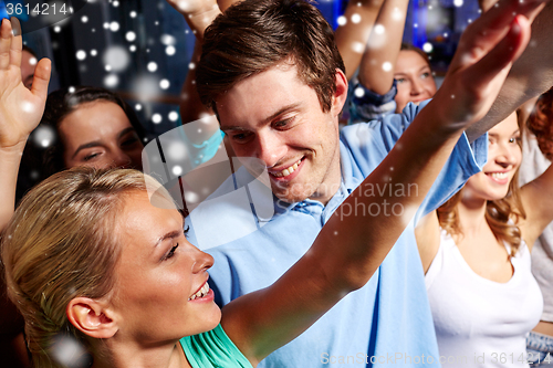 Image of smiling friends at concert in club