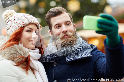 Image of couple taking selfie with smartphone in old town